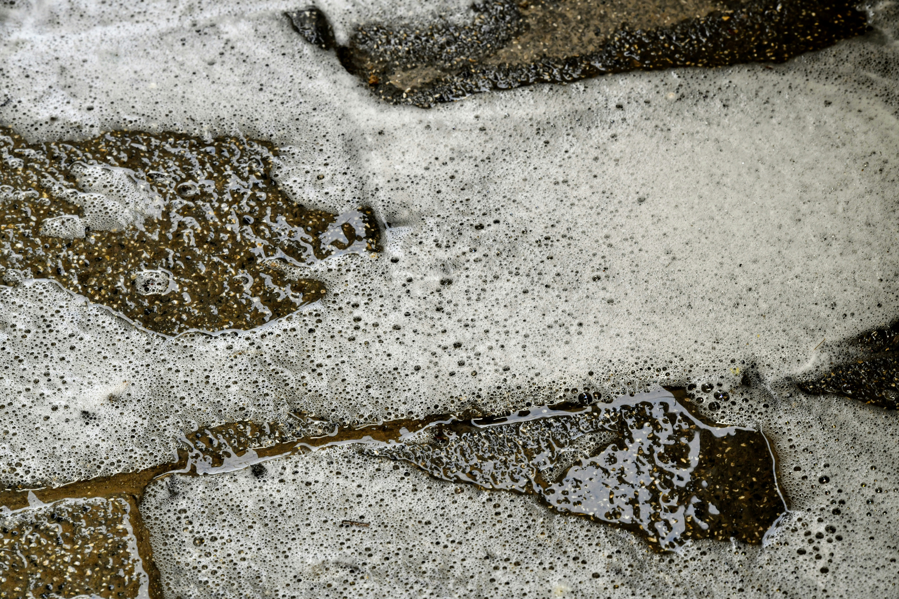 Heißes Wasser wird auf Steinplatten im Garten gegossen